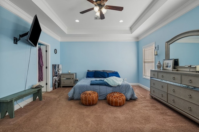 carpeted bedroom with a tray ceiling, a ceiling fan, visible vents, and ornamental molding