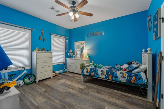 bedroom featuring wood finished floors, visible vents, and ceiling fan