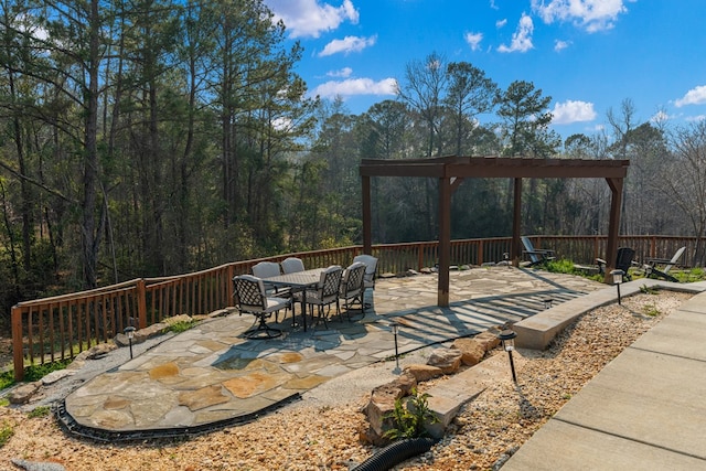 view of patio with a forest view and outdoor dining space