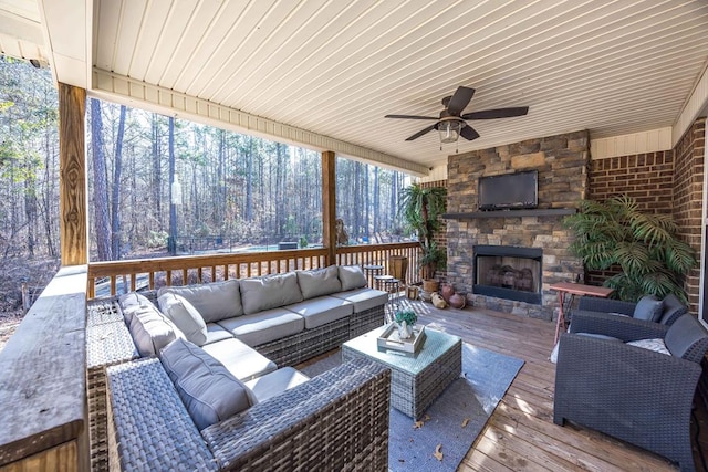 exterior space with an outdoor living space with a fireplace and ceiling fan