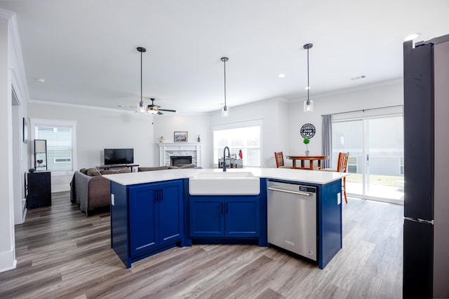 kitchen with blue cabinetry, dishwasher, sink, an island with sink, and light wood-type flooring