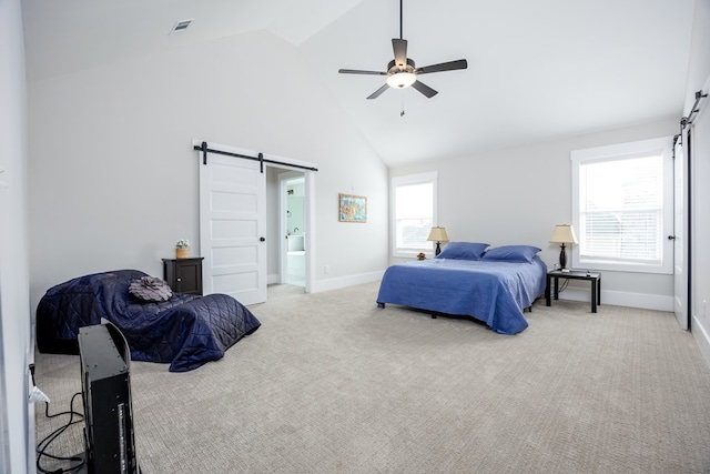 carpeted bedroom with a barn door, ensuite bathroom, high vaulted ceiling, and ceiling fan