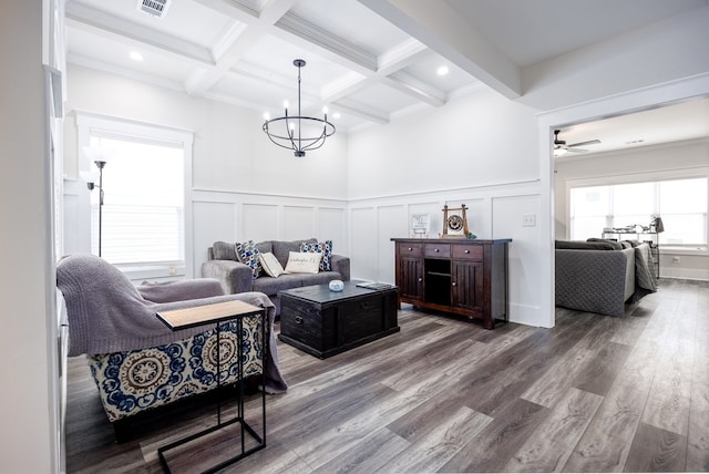 living room featuring wood-type flooring, a healthy amount of sunlight, and beam ceiling