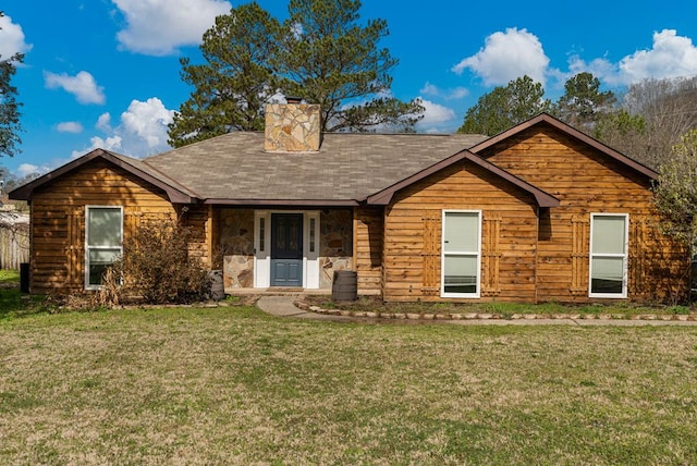 view of front of home with stone siding, a front lawn, and a chimney