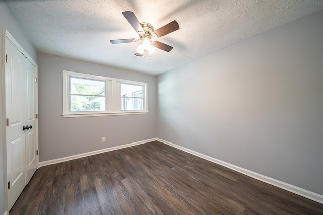 spare room with ceiling fan, dark hardwood / wood-style flooring, and a textured ceiling