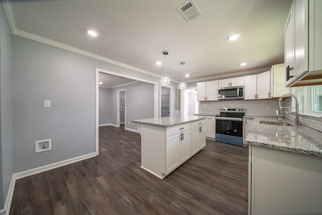 kitchen with white cabinets, sink, a kitchen island, and appliances with stainless steel finishes