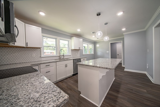 kitchen with white cabinetry, sink, stainless steel appliances, decorative light fixtures, and a kitchen island