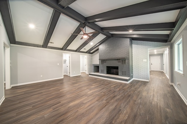 unfurnished living room featuring brick wall, ceiling fan, dark wood-type flooring, a fireplace, and vaulted ceiling with beams