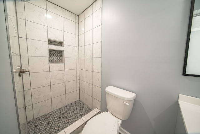 bathroom with tiled shower and toilet