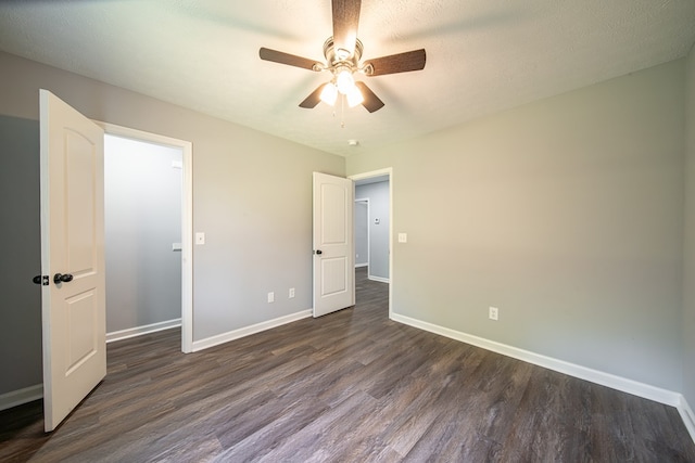 unfurnished bedroom with a textured ceiling, dark hardwood / wood-style floors, and ceiling fan