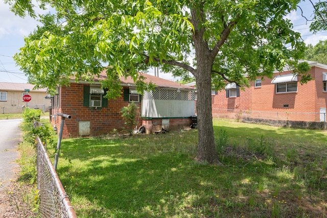 view of front of home with fence, crawl space, a front lawn, and brick siding