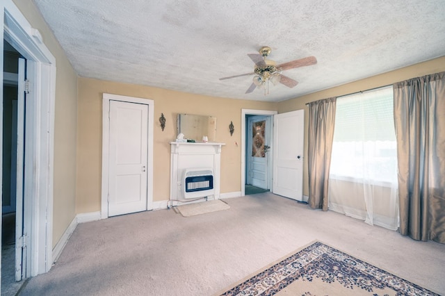 unfurnished living room featuring heating unit, ceiling fan, and carpet