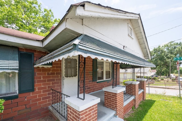view of side of home featuring fence and brick siding