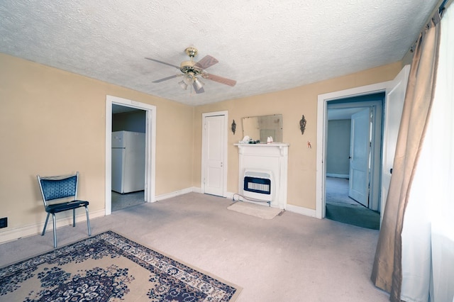 unfurnished living room featuring carpet floors, ceiling fan, heating unit, and baseboards