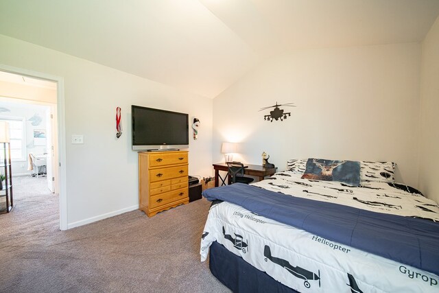 carpeted bedroom with baseboards and lofted ceiling