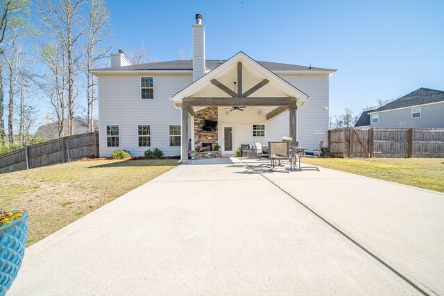 rear view of house with a fenced backyard, a lawn, a chimney, and a ceiling fan
