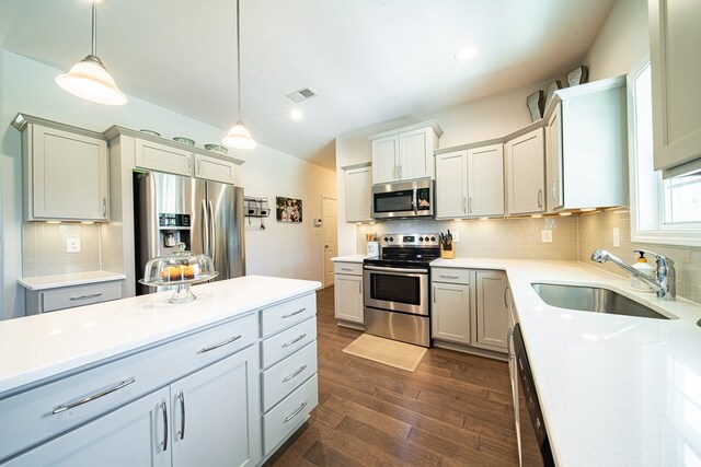 kitchen with light countertops, visible vents, dark wood finished floors, appliances with stainless steel finishes, and a sink