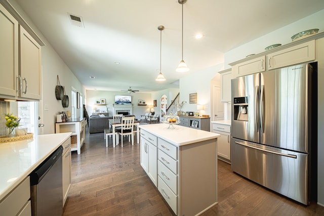kitchen with light countertops, ceiling fan, appliances with stainless steel finishes, and dark wood-type flooring