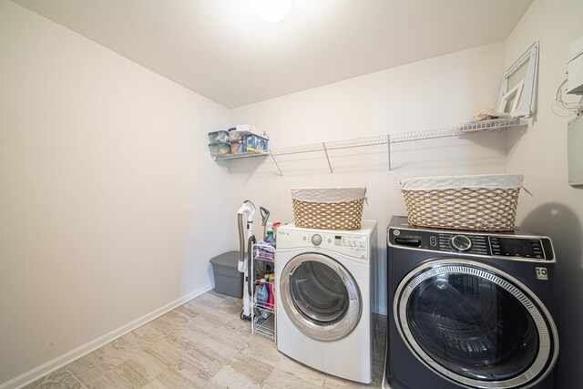washroom featuring baseboards, washer and dryer, and laundry area