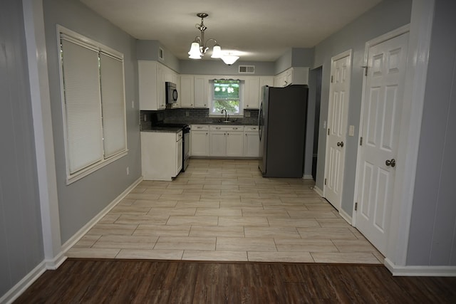 3919 Gray Fox Dr, Columbus, GA 31909 - kitchen with black appliances, light wood-style flooring, a chandelier, and dark countertops