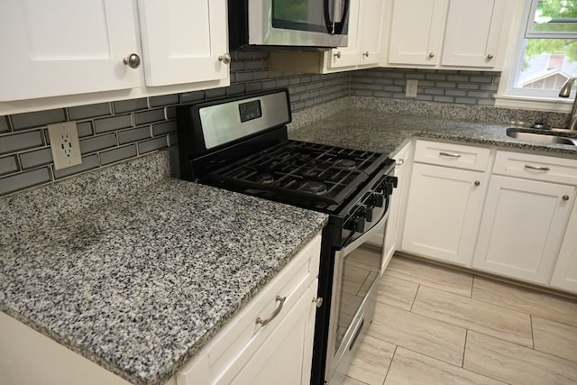 3919 Gray Fox Dr, Columbus, GA 31909 - kitchen with appliances with stainless steel finishes, white cabinets, tasteful backsplash, and stone countertops