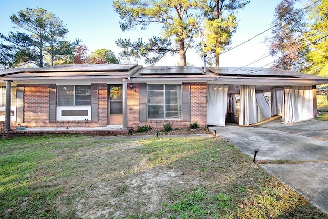 view of front facade featuring driveway, an attached carport, a front lawn, and brick siding