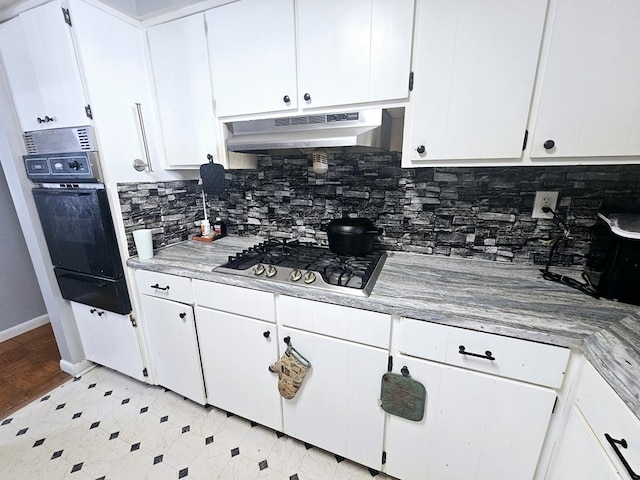 kitchen with wall oven, under cabinet range hood, white cabinets, a warming drawer, and stainless steel gas stovetop