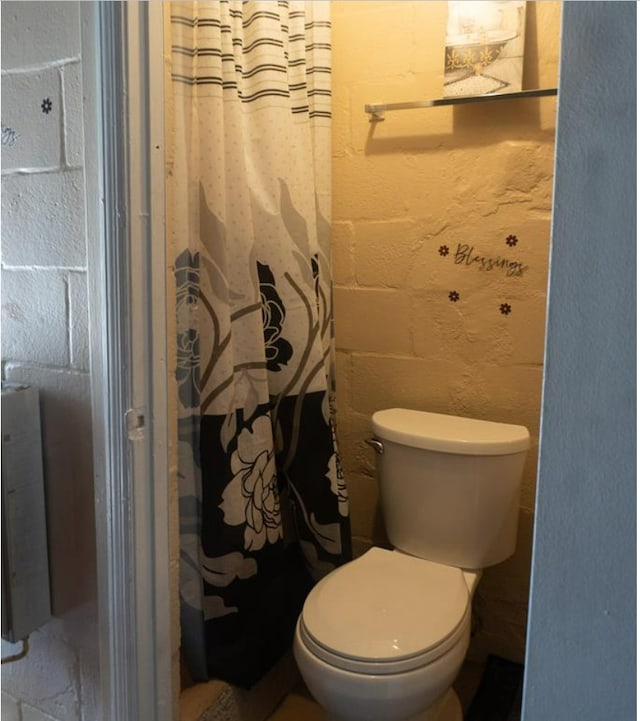 bathroom with toilet and curtained shower