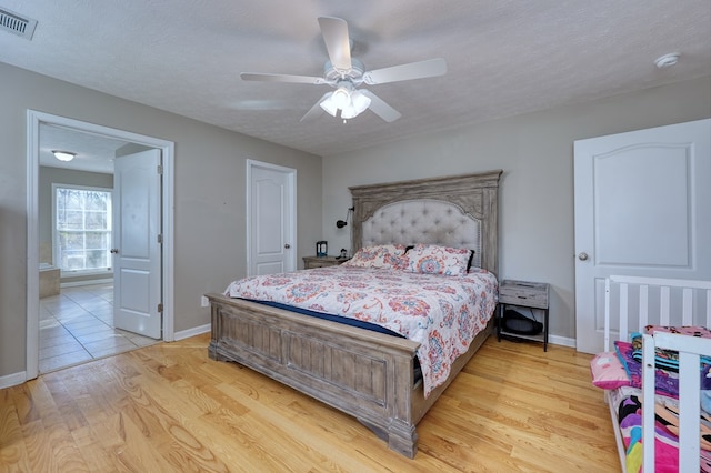 15 Whitetail Rd, Seale, AL 36875 - bedroom with light wood-type flooring, connected bathroom, a ceiling fan, and a textured ceiling
