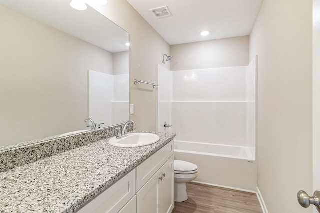 full bathroom with hardwood / wood-style floors, vanity, toilet, and tub / shower combination