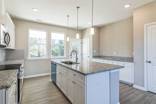 kitchen featuring appliances with stainless steel finishes, sink, a kitchen island with sink, and white cabinets