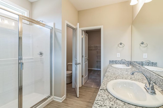 bathroom with an enclosed shower, vanity, toilet, and hardwood / wood-style floors