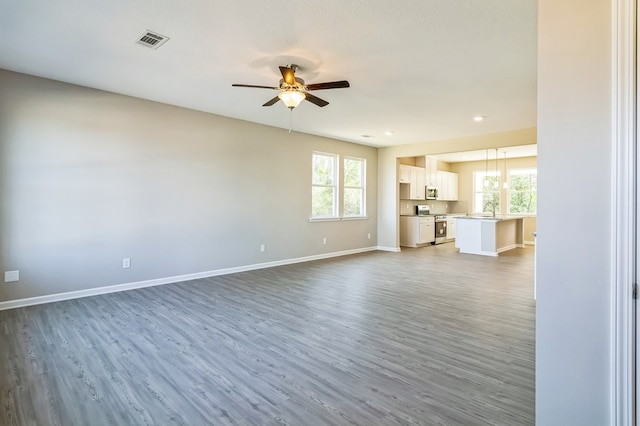 unfurnished living room with ceiling fan, dark wood-type flooring, a textured ceiling, and sink