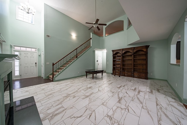 unfurnished living room with marble finish floor, visible vents, ceiling fan, baseboards, and stairs