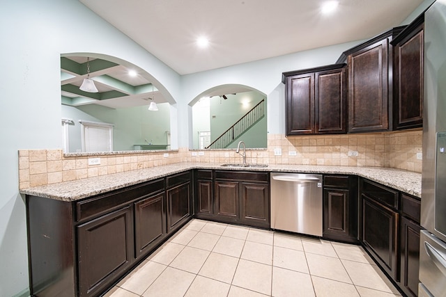 kitchen featuring a sink, light tile patterned floors, backsplash, and dishwasher