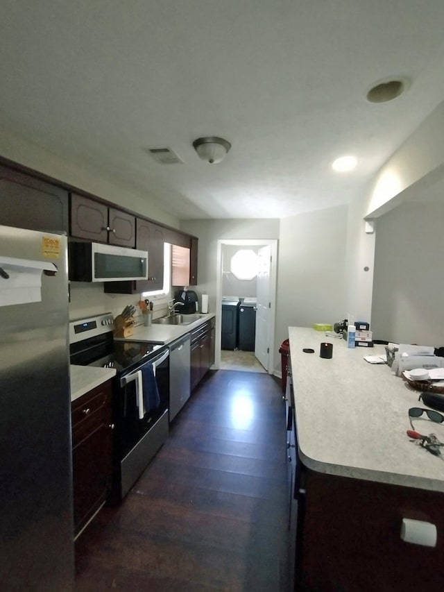 6099 Mary Allison Dr, Columbus, GA 31907 - kitchen with stainless steel appliances, washing machine and clothes dryer, light countertops, and dark wood-type flooring