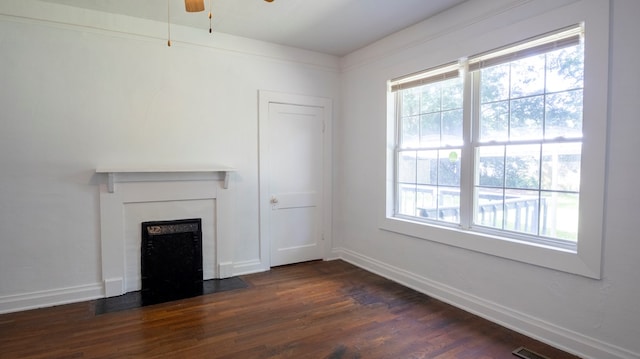 400 Lawrence St, Hogansville, GA 30230 - unfurnished living room with a fireplace with flush hearth, dark wood-style floors, and a ceiling fan