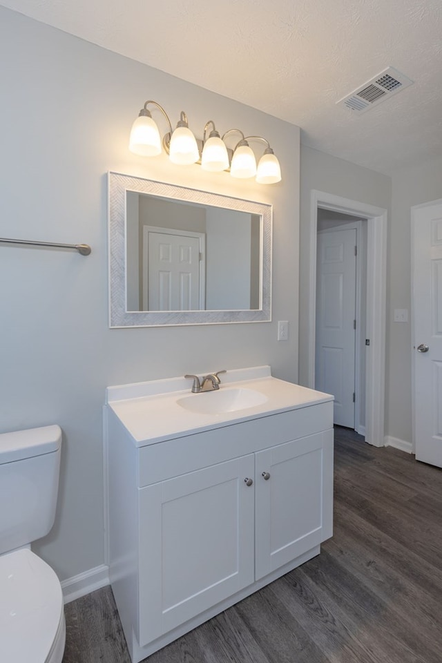 bathroom featuring hardwood / wood-style floors, vanity, and toilet