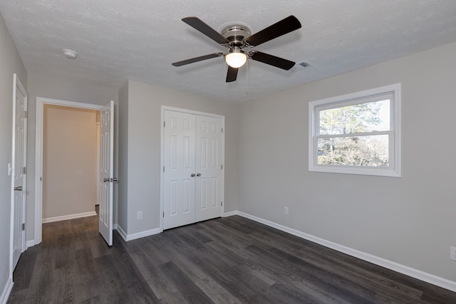 unfurnished bedroom with ceiling fan, dark hardwood / wood-style flooring, and a closet