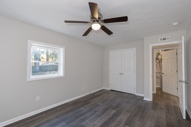 unfurnished bedroom featuring ceiling fan, dark hardwood / wood-style floors, a textured ceiling, and a closet