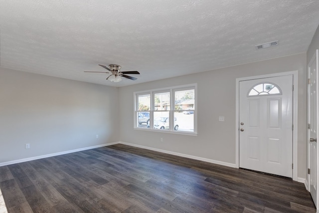 entrance foyer with ceiling fan, a healthy amount of sunlight, dark hardwood / wood-style flooring, and a textured ceiling