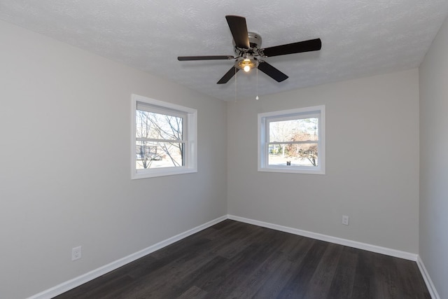 spare room featuring a wealth of natural light, dark hardwood / wood-style flooring, ceiling fan, and a textured ceiling