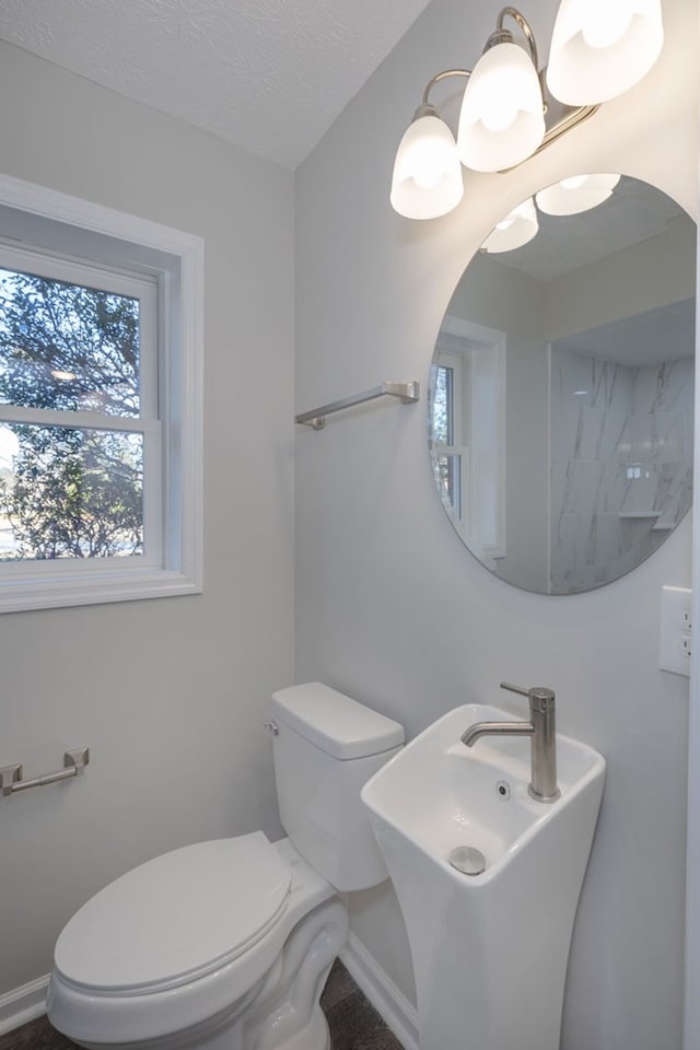 bathroom with sink, a textured ceiling, and toilet