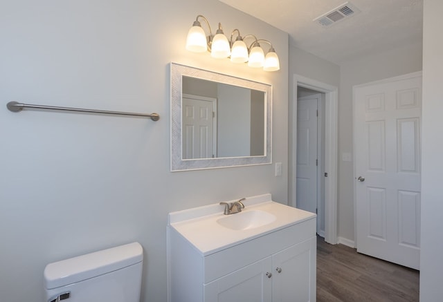 bathroom with vanity, wood-type flooring, a textured ceiling, and toilet