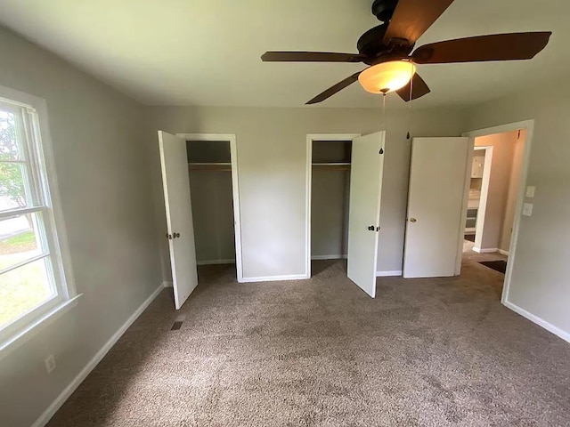 carpeted empty room with a healthy amount of sunlight, baseboards, and visible vents