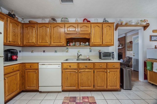kitchen with brown cabinetry, dishwasher, a sink, light countertops, and light tile patterned floors