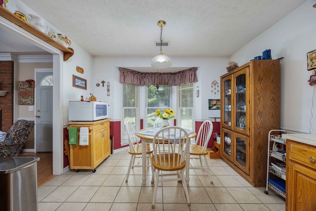 dining space featuring visible vents, a textured ceiling, and light tile patterned floors
