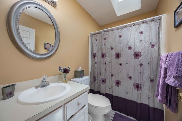 bathroom with vanity, toilet, a shower with shower curtain, tile patterned floors, and a skylight