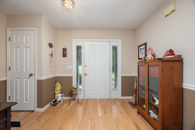 entrance foyer with baseboards and wood finished floors