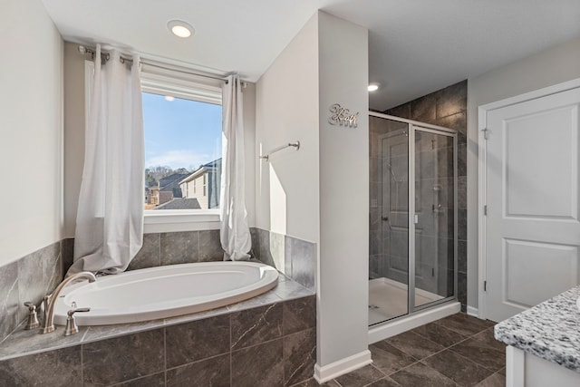 full bathroom featuring a shower stall, a garden tub, and tile patterned floors